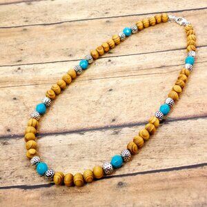 Wood bead necklace created with turquoise color beads and textured silver beads.